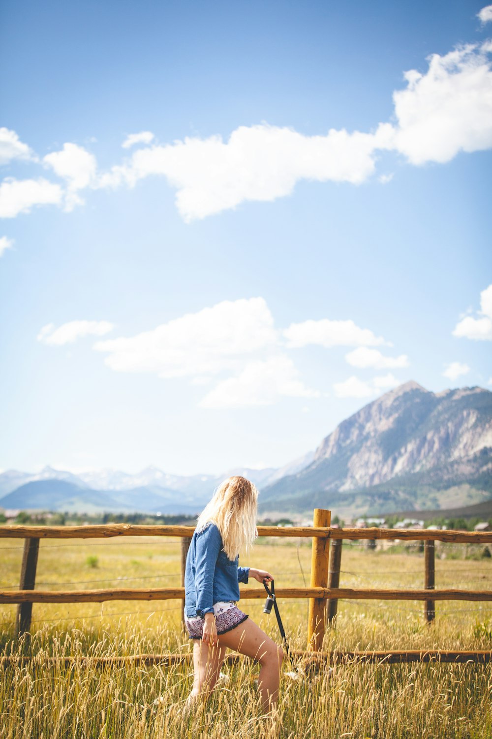 donna in felpa blu che cammina sul campo