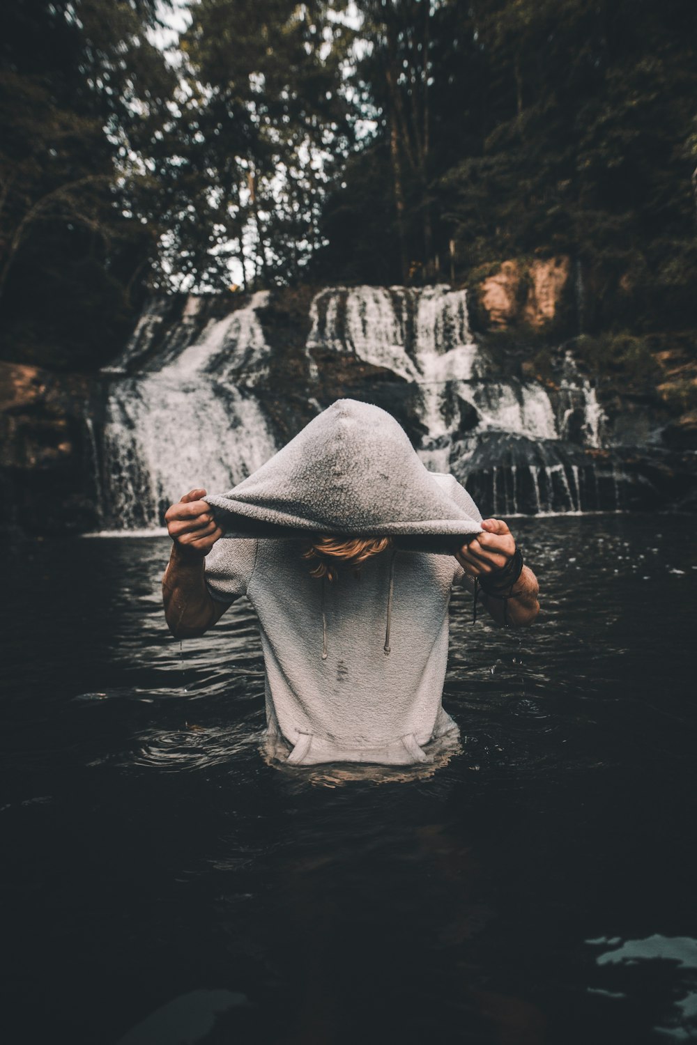 man in gray pullover hoodie in body of water