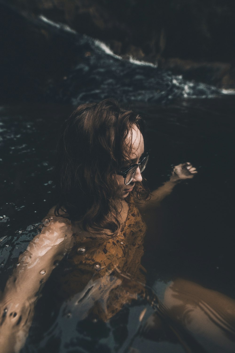 Mujer con anteojos en el cuerpo de agua