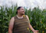 A joyful traveler participating in a traditional corn workshop, surrounded by vibrant native maize plants.