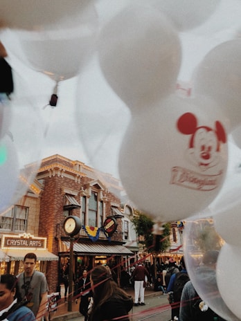 A festive scene with balloons and banners announcing a special sale event.