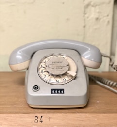 gray rotary telephone on brown table