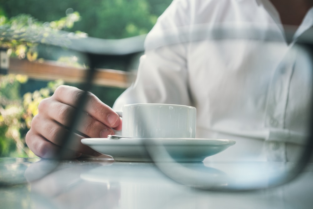 person holding ceramic teacup