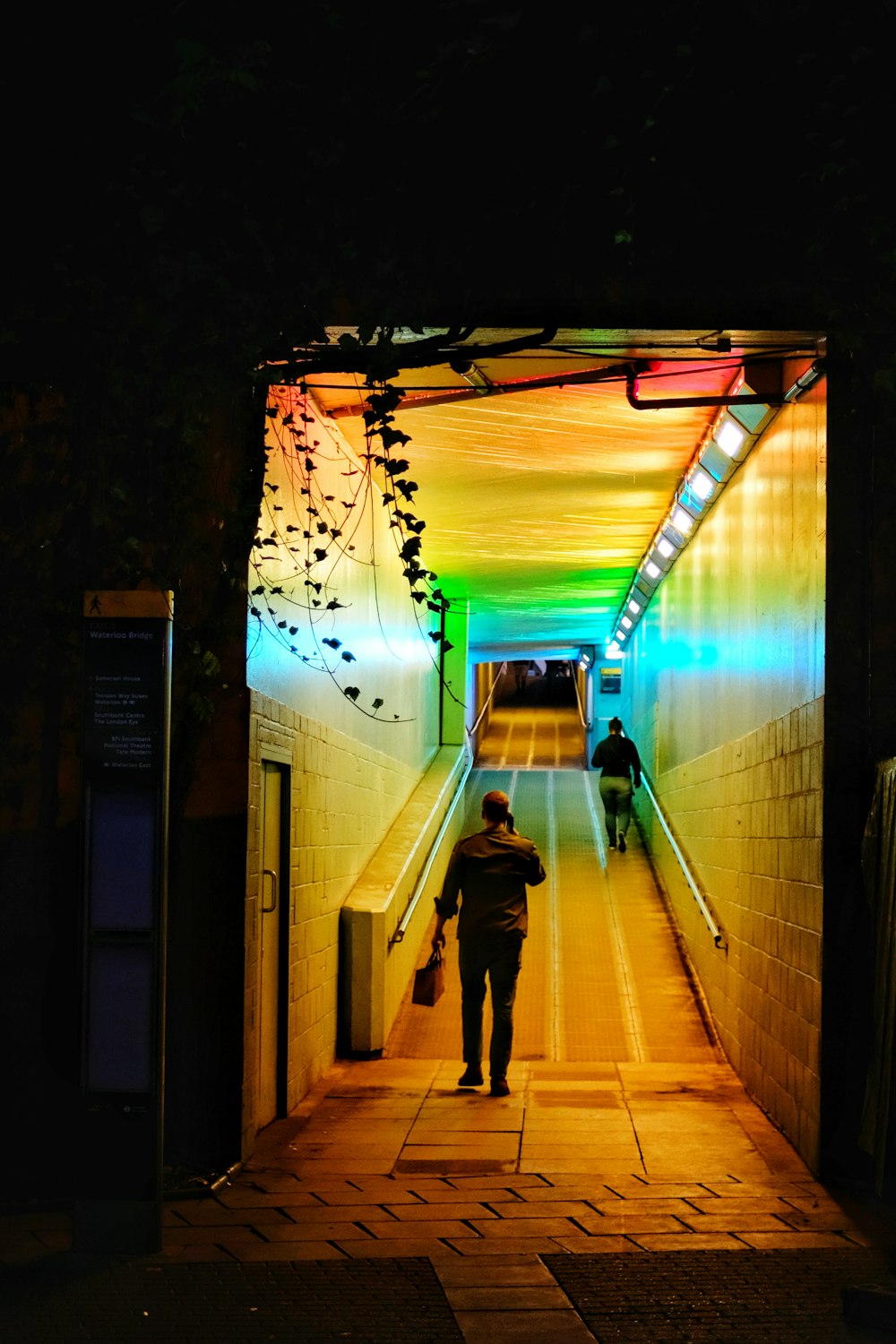 person holding bag standing in front of stair