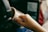 A close-up image features a child's hand holding a white mug. In the background, there are headphones on the child's head and a blurred screen, possibly a tablet or laptop.