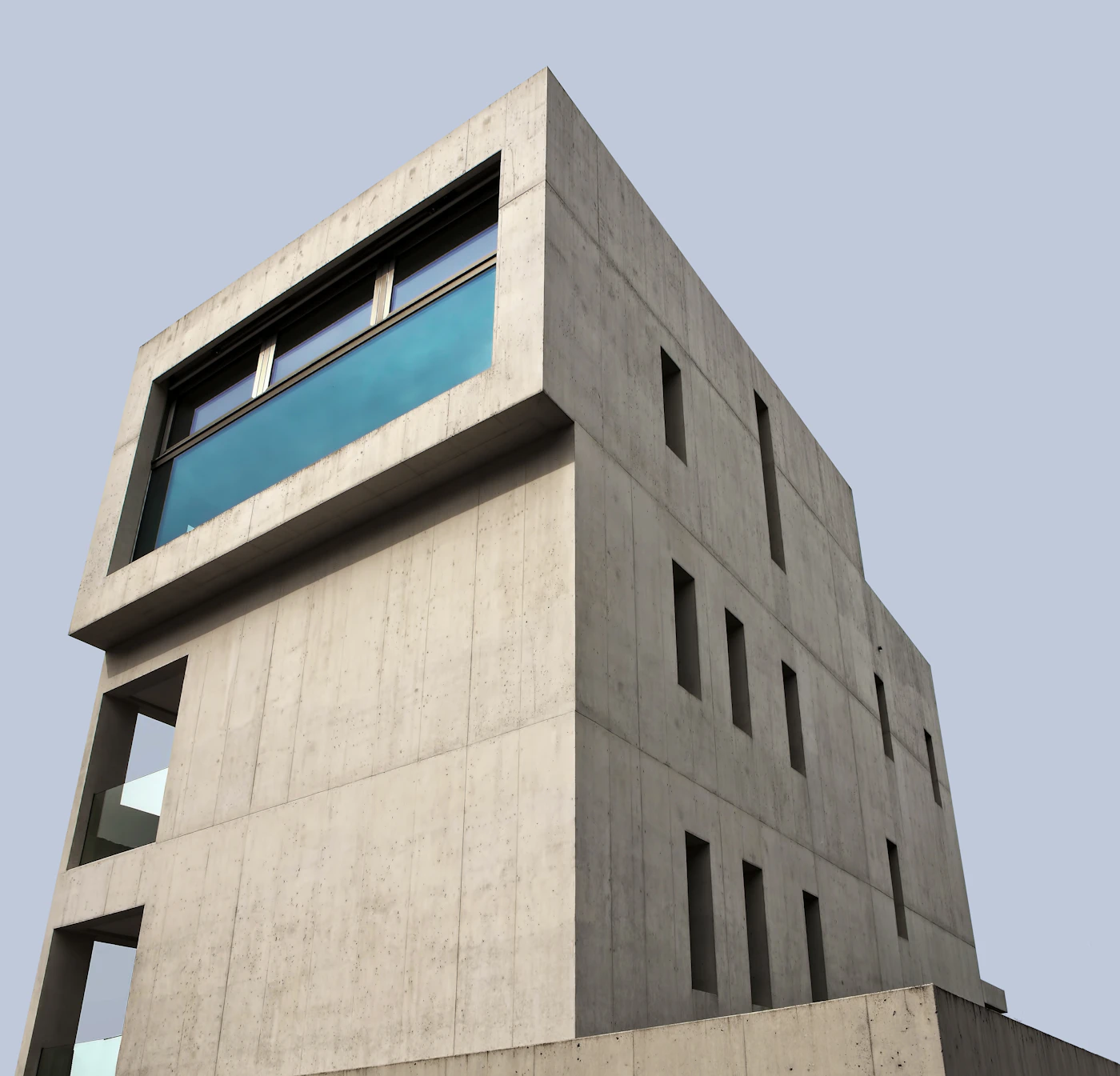 Maison en béton brut percée d'une longue baie horizontale