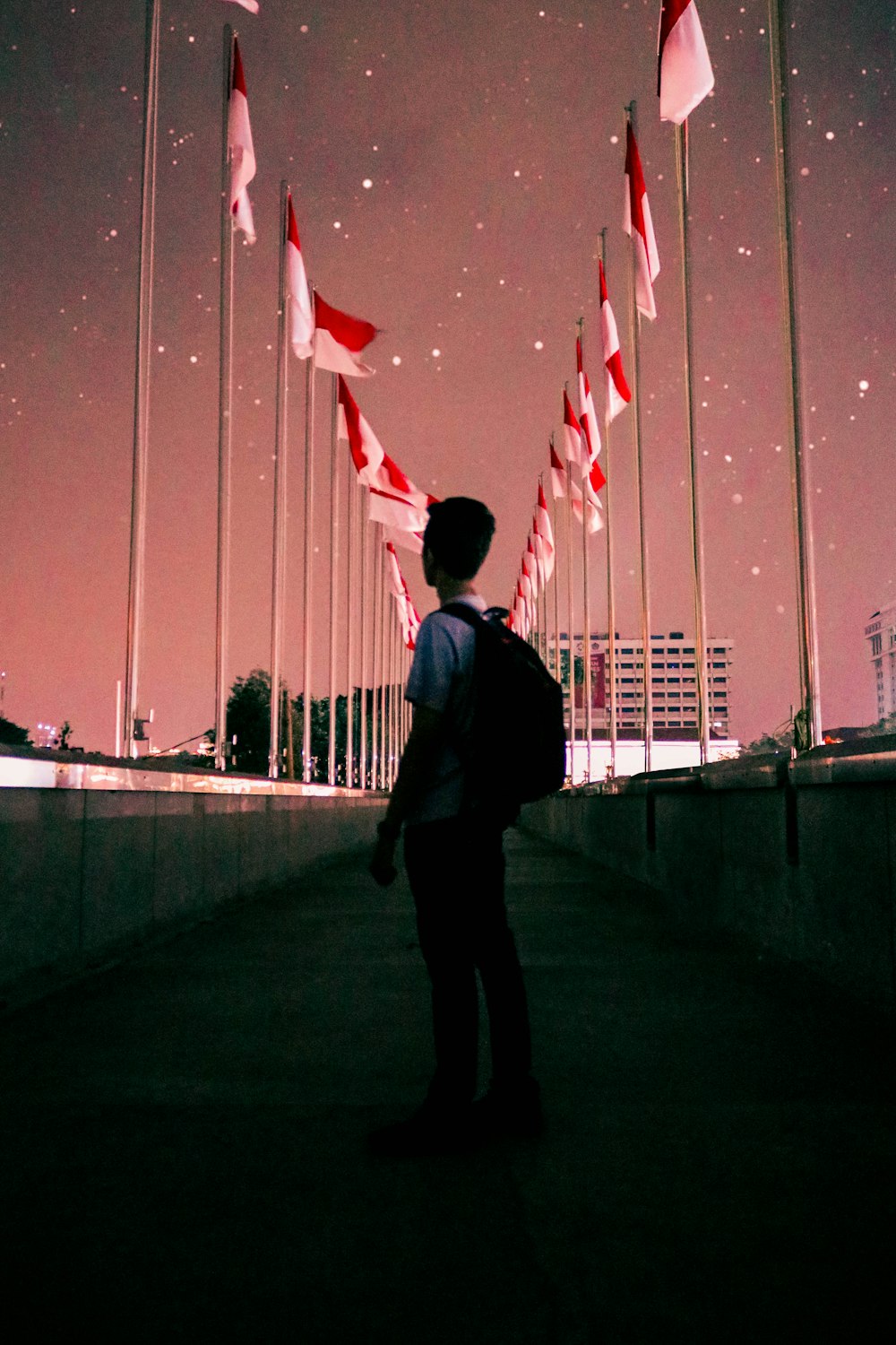 man standing on bridge during night time