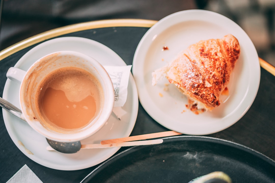 cup of coffee on table and baked bread on plate