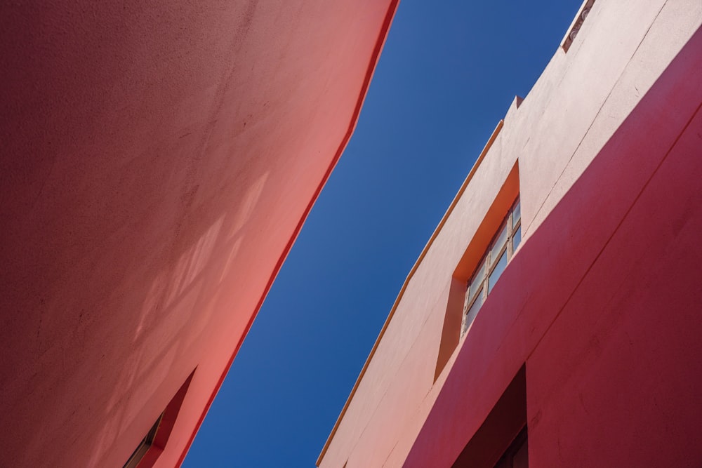 a red building with two windows and a blue sky