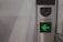 A metallic turnstile with a green arrow indicating the direction to proceed. The panel is labeled 'WAG 011.' The setting suggests a modern, controlled-access area such as a subway or train station.