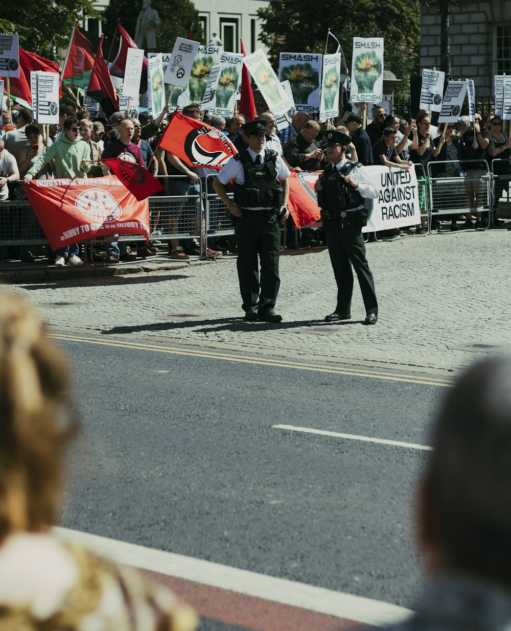 two policemen standing beside group of people