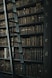 library shelf near black wooden ladder