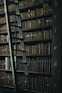 library shelf near black wooden ladder
