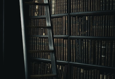 black wooden ladder beside brown wooden bookshelf