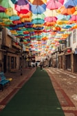 assorted-color umbrella covering alley during daytime