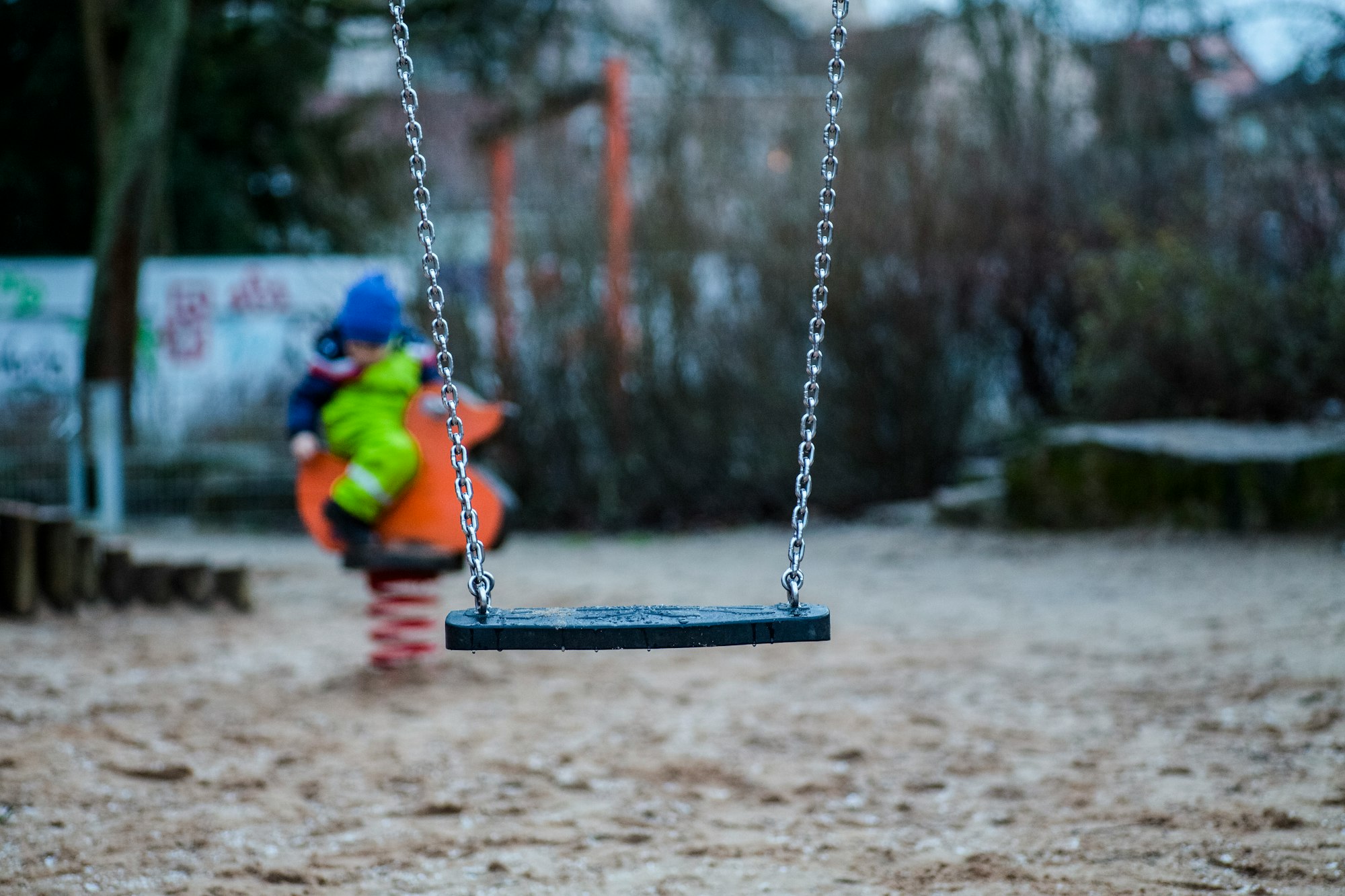 black swing chair hanging by gray chain