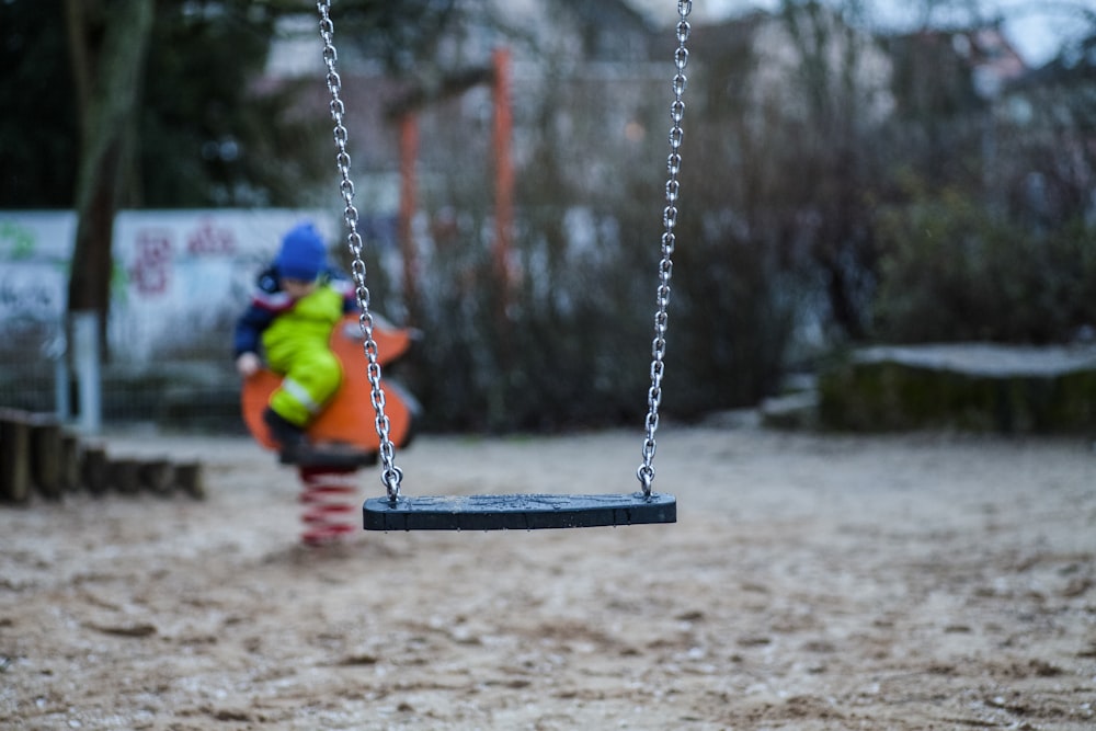 black swing chair hanging by gray chain