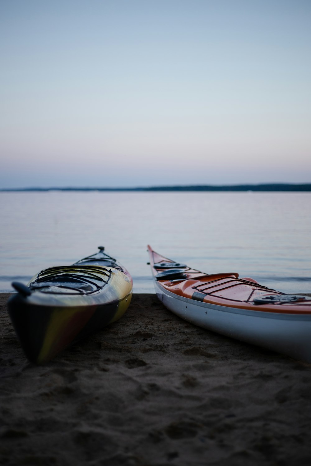 two yellow and orange canoes on beach