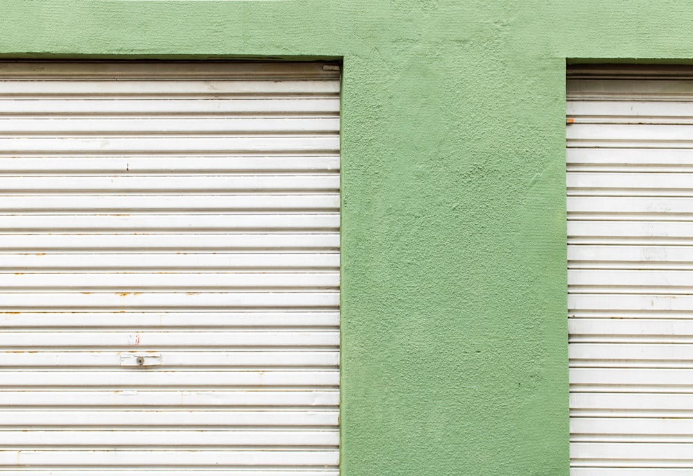 grey steel roller-shutter near green wall