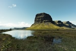 green plateau near water and grass field