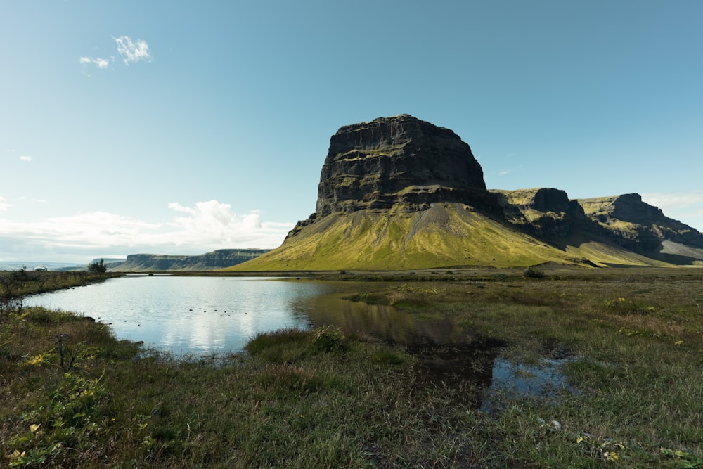 green plateau near water and grass field