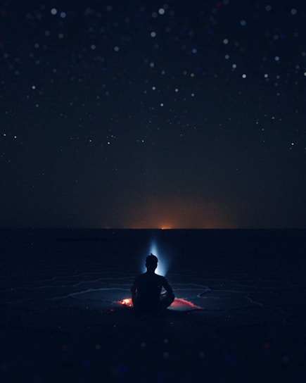 A mystical landscape depicting a solitary figure meditating under a starry sky.