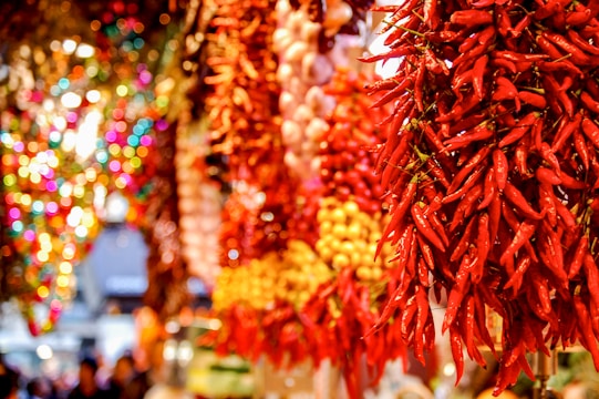 Vibrant market scene with colorful Mexican sauces and dried chili peppers displayed.