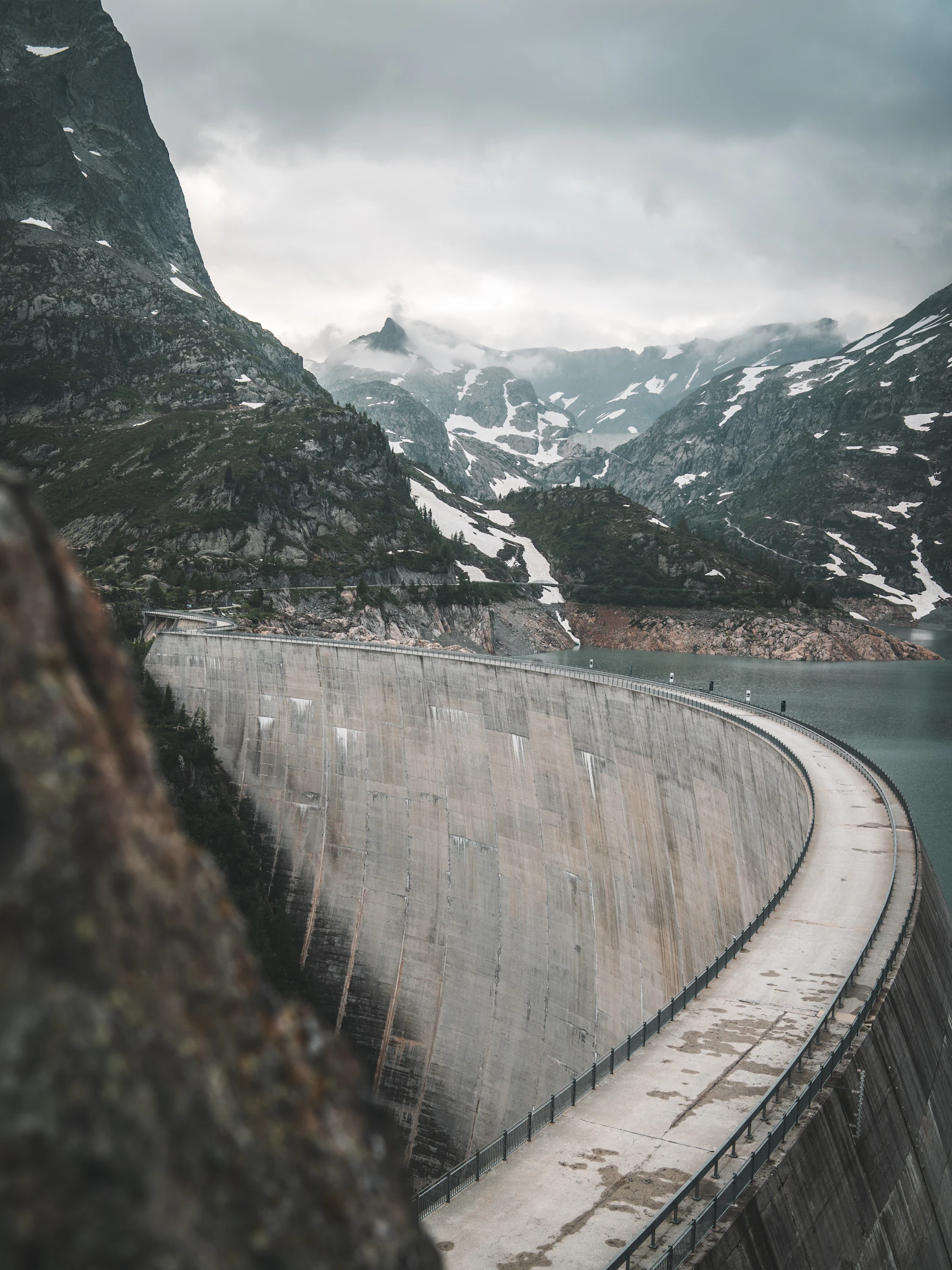 Grand barrage en béton au pied d'un sommet dans les Alpes suisses (image d'illustration)
