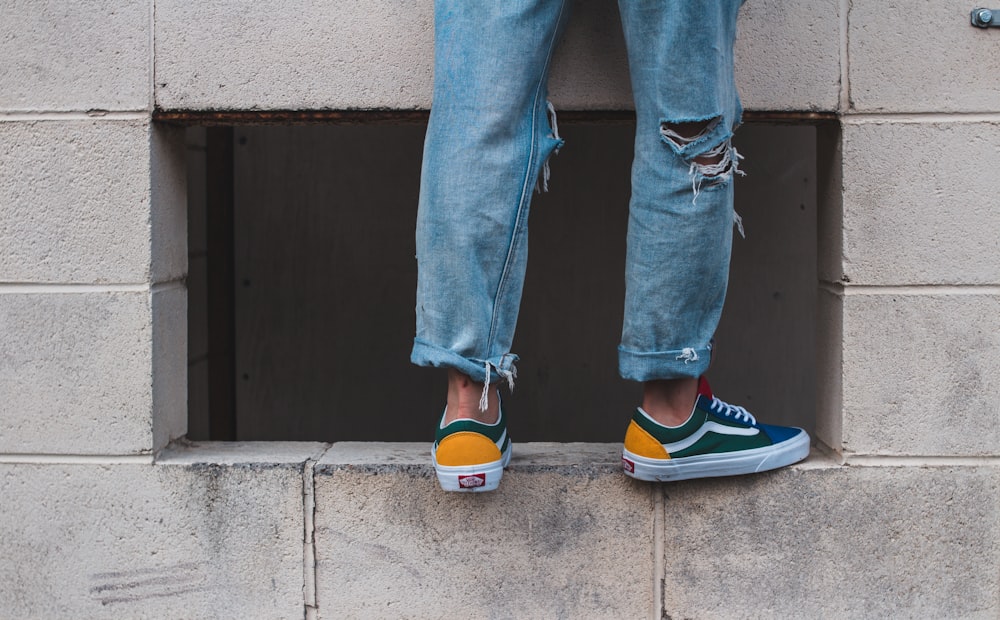 man in pair of green-and-white low-top vans