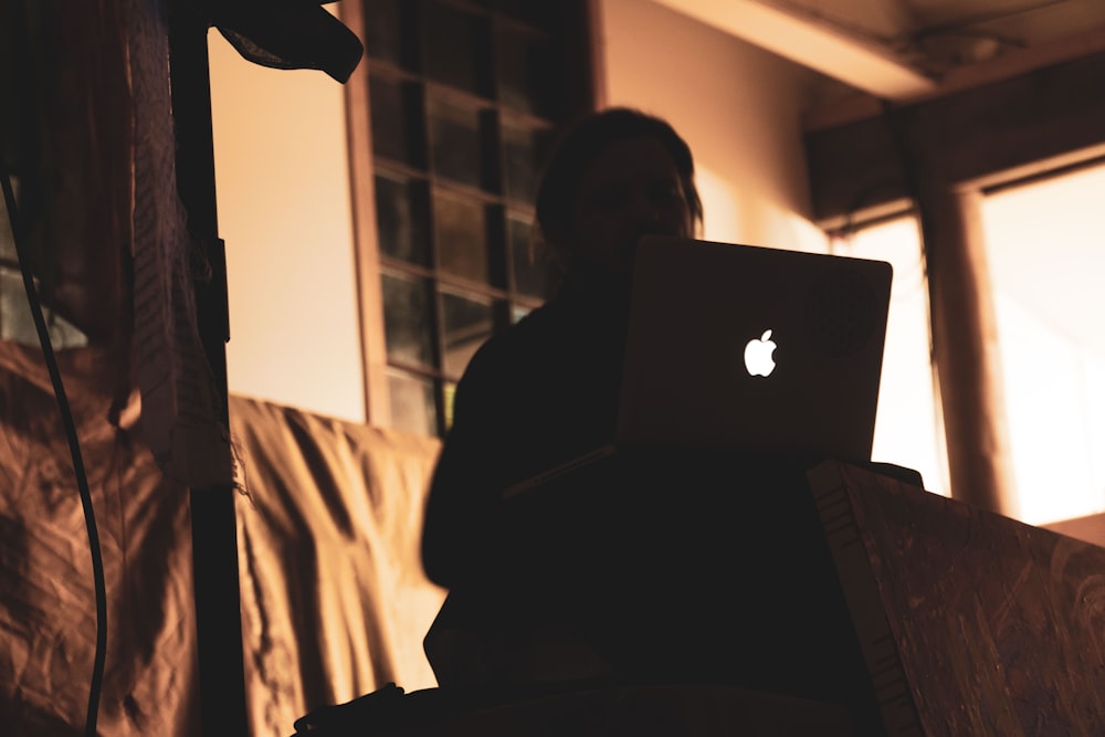 person using Apple laptop in the room