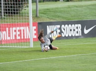 A close-up of a goalkeeper diving to make a crucial save during a tense match.