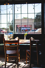 A softly lit café table with two coffee cups and a single flower in a vase, capturing the moment they first met.