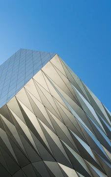 Close-up of a building facade showing sharp vertical lines and glass reflecting sunlight
