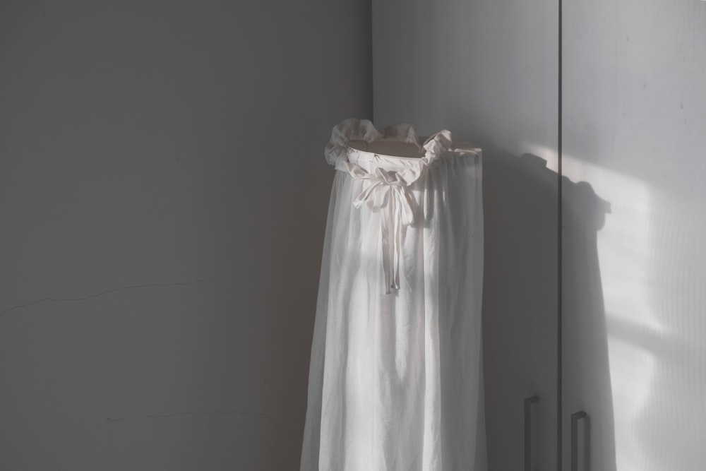 a white curtain hanging on a white wall