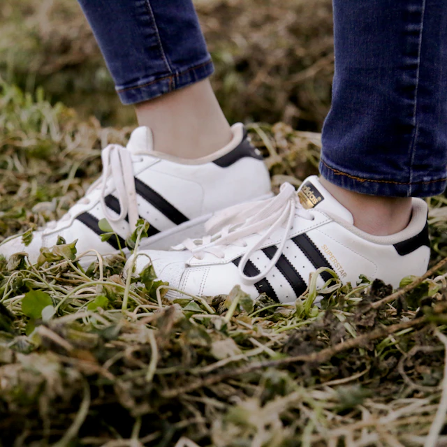 A woman wearing white adidas Superstar shoes outdoors in British Columbia