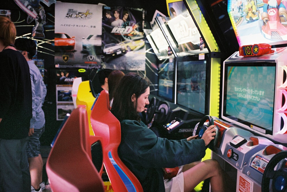 mulher dirigindo máquina arcade