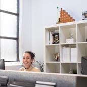 Smiling professional assisting a client in a bright workspace.