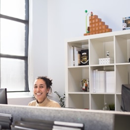 Smiling professional assisting a client in a bright workspace.