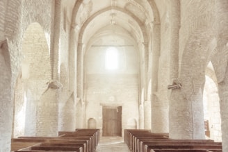 A serene church interior with warm lighting and wooden pews, inviting worshippers to gather.