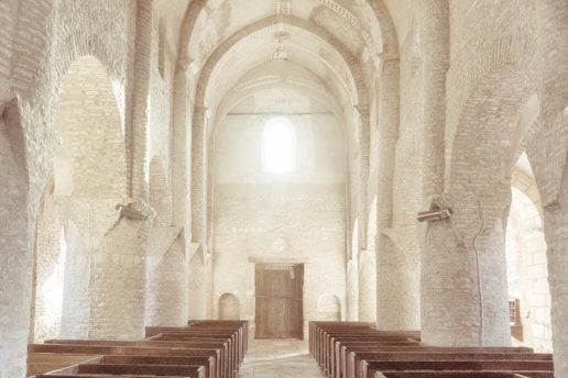 A serene church interior with warm lighting and wooden pews, inviting worshippers to gather.