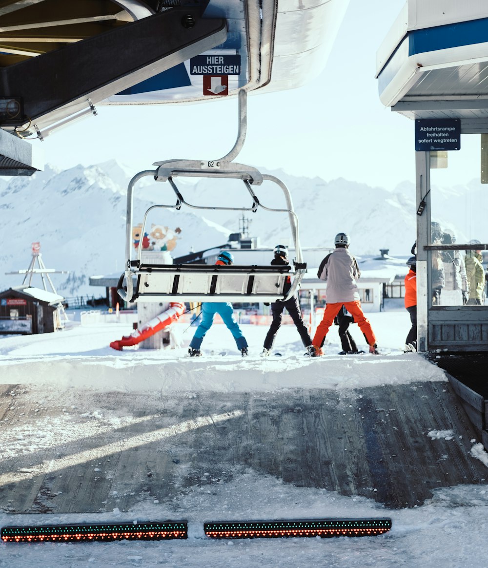 Gezin die uit de skilift stapt met ski uitrusting aan 