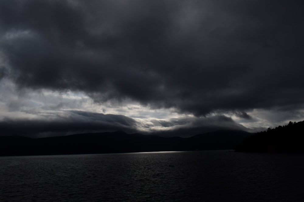 nubes grises sobre el cuerpo de agua durante el día