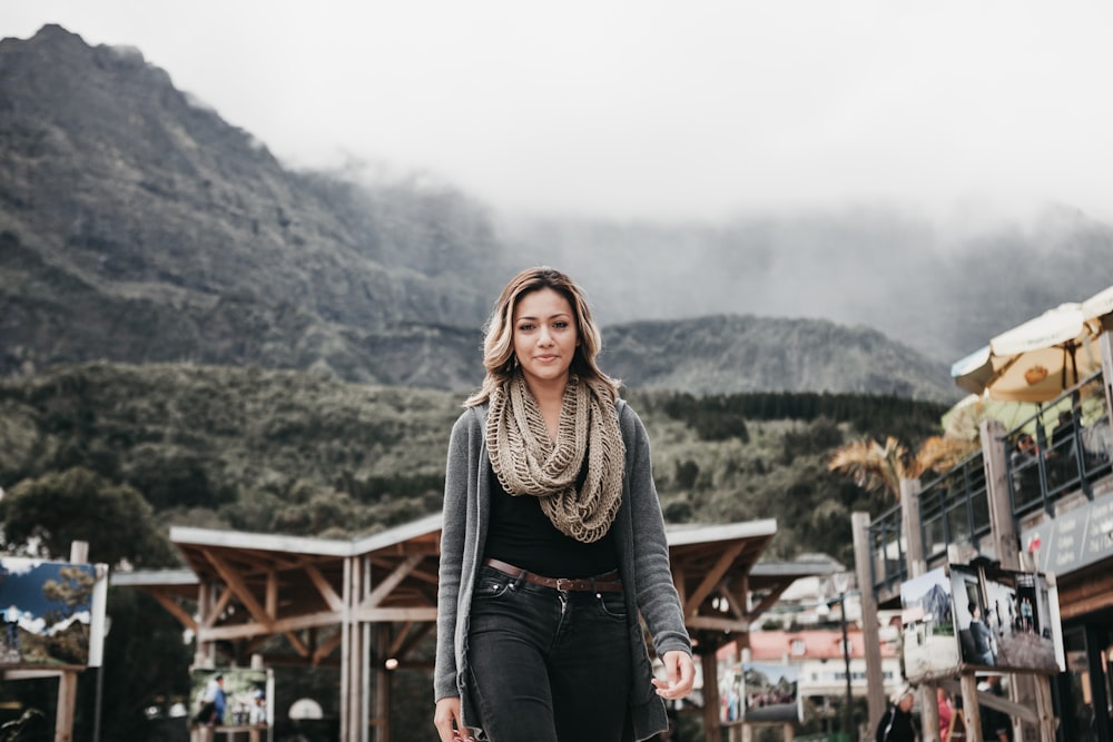 woman wearing black denim bottoms standing near building