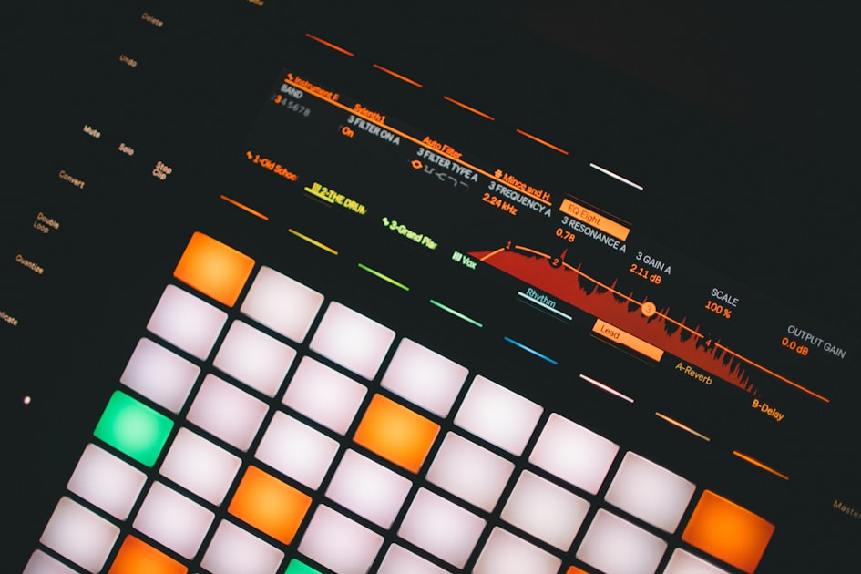 Illuminated Ableton Push 2 MIDI controller pad grid glowing in a dark studio, used for hands-on electronic music production