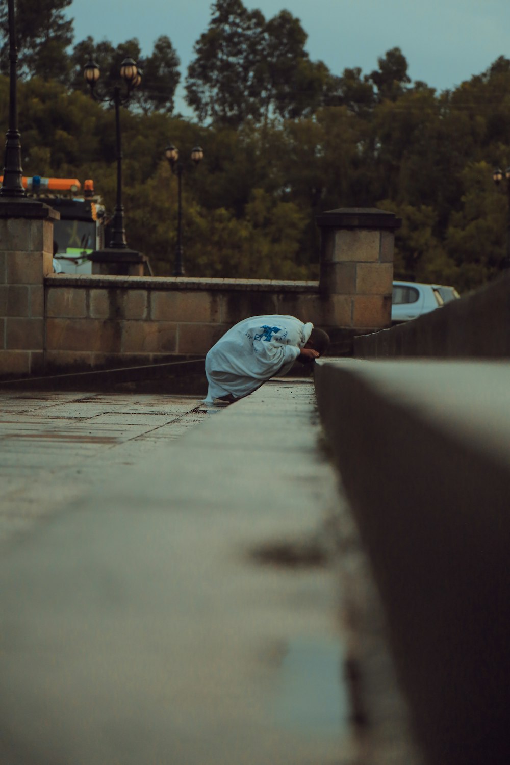 person kneeling on gray concrete stair outdoor during daytime