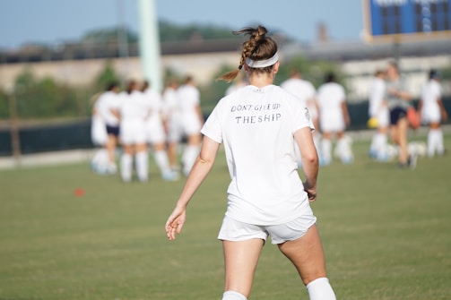 woman standing in front of women at the field during day