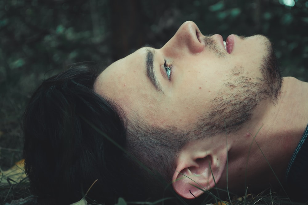 man lying on grass field