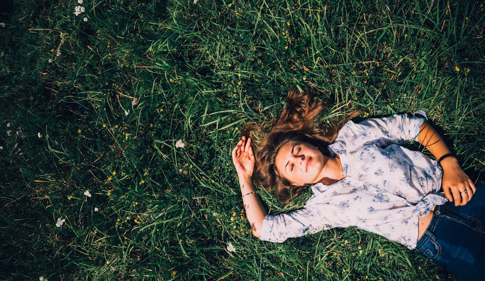 woman lying on grass during daytime