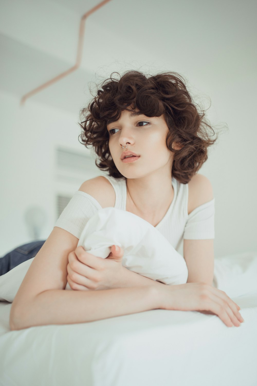 woman in white shirt lying on bed