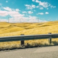 gray road barrier near wind farm